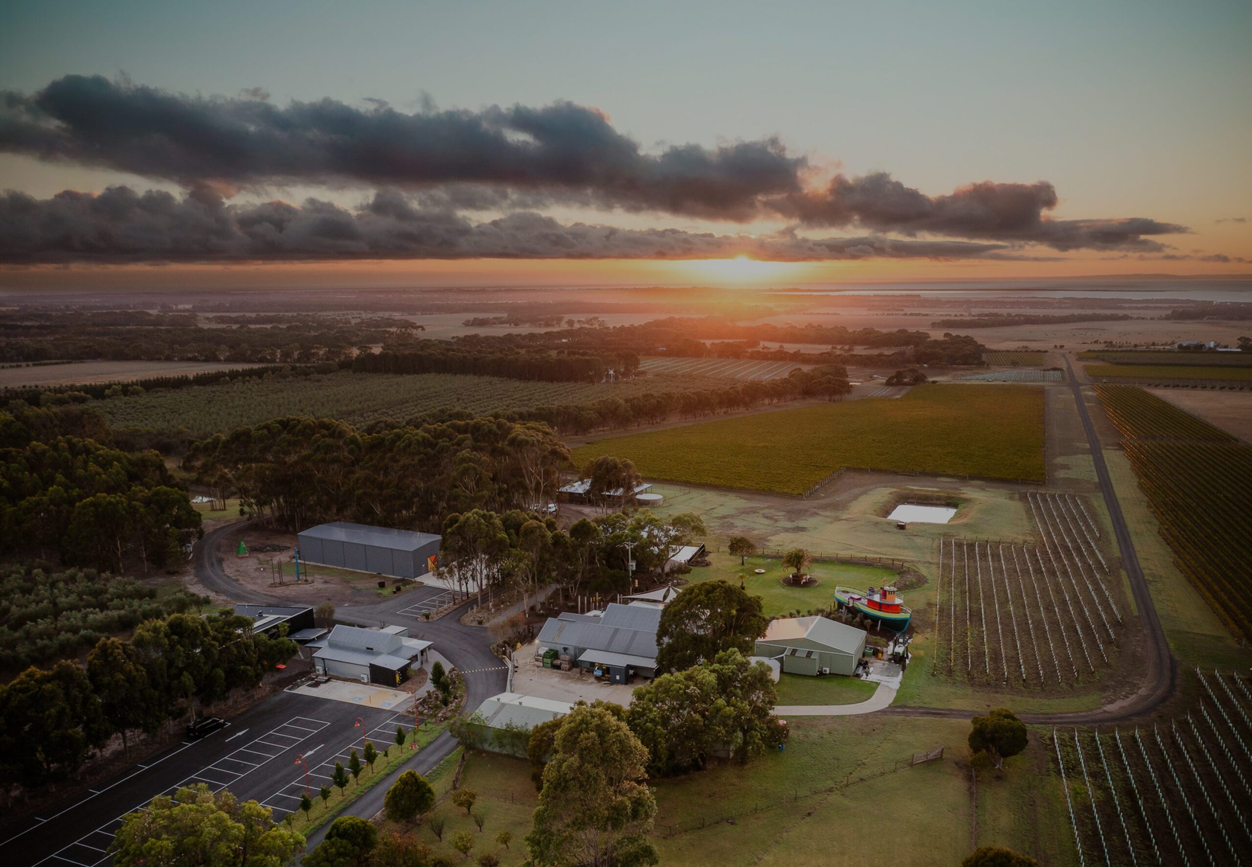 Aerial view of Quiddity Place vineyards and buildings at sunset